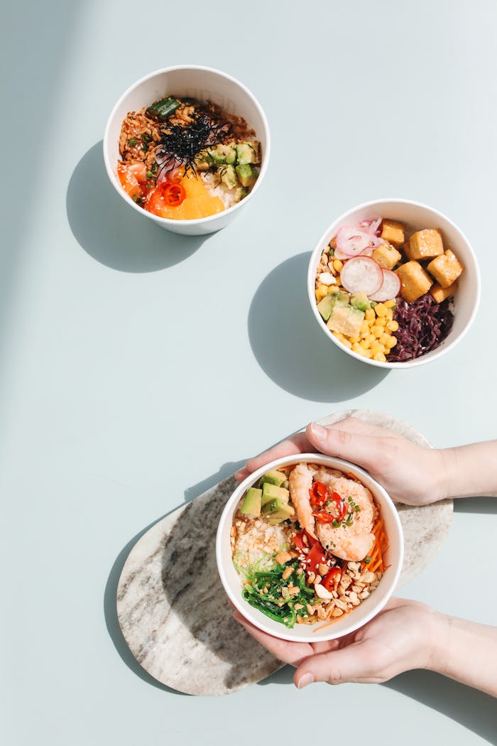 ours-journey Overhead shot of assorted poke bowls with fresh ingredients like salmon, avocado, and tofu.