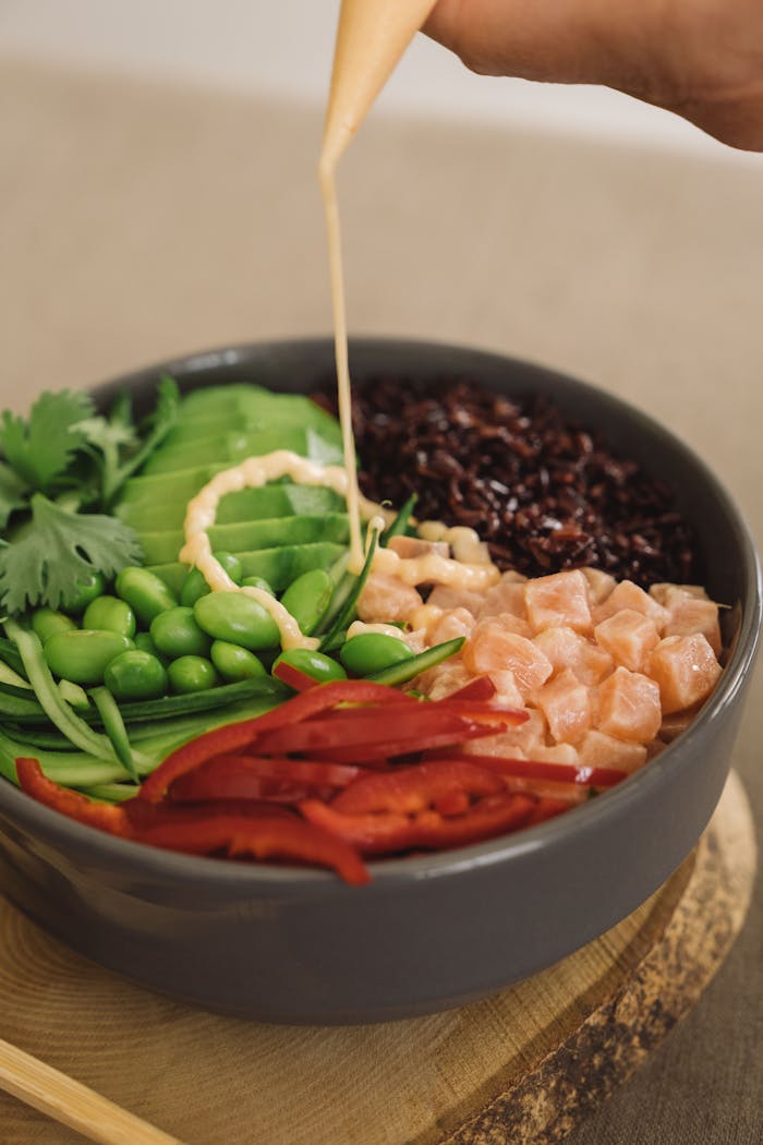 about-02 A vibrant Buddha bowl with fresh vegetables and dressing, perfect for healthy eating.